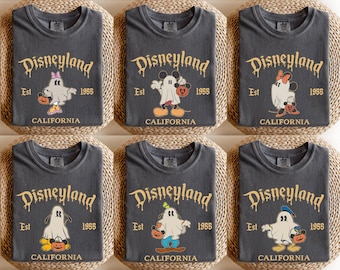 May include: Six gray t-shirts with a Disneyland Halloween theme. Each shirt features the Disneyland logo, the text "Est 1955 CALIFORNIA", and a cartoon ghost holding a pumpkin. Some ghosts are dressed as Mickey and Minnie Mouse.