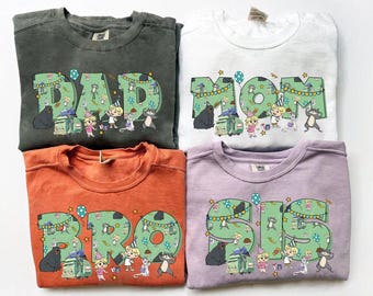 May include: Four crewneck sweatshirts in gray, white, orange, and lavender. Each shirt features a large, colorful graphic with the words "DAD", "MOM", "BRO", and "SIS", decorated with cartoon characters and party elements.