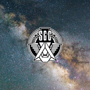 May include: Black and white graphic design of a winged symbol with the letters "SGC" in a circle. The design is set against a background of a starry night sky.