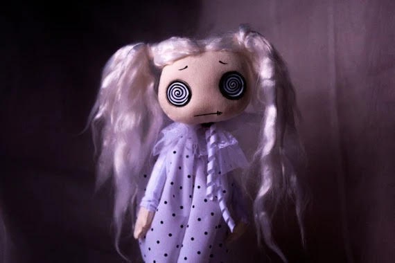 大きな催眠ボタンの目を持つ不気味でかわいいゴーストゴス布人形。黒と