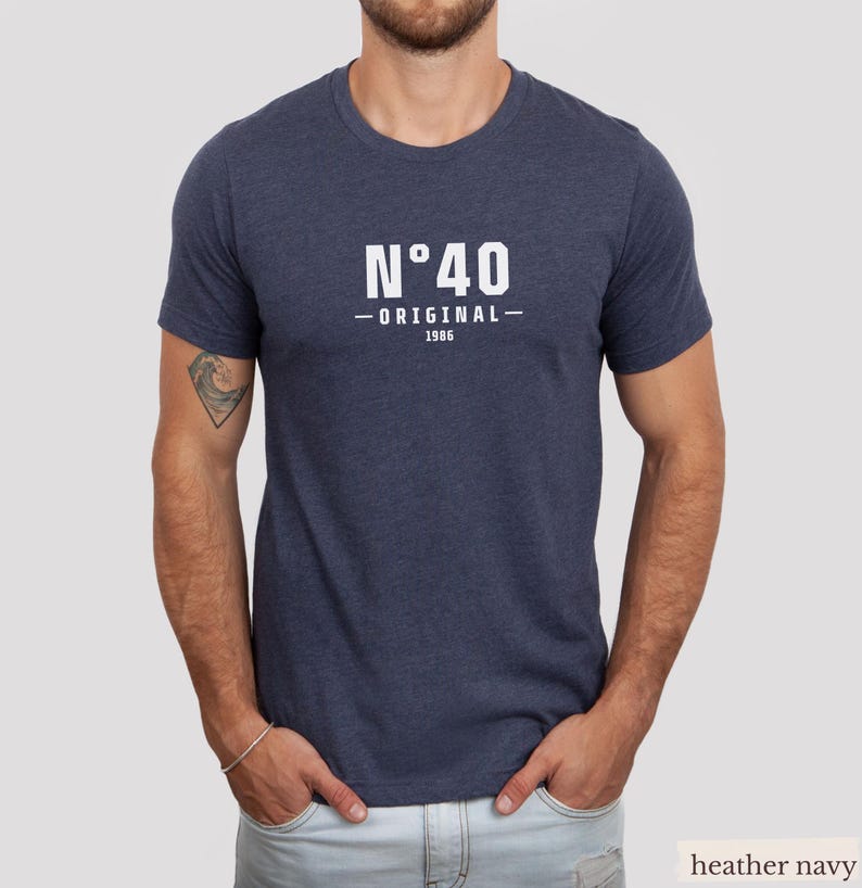 May include: A heather navy blue short-sleeve t-shirt featuring white text on the chest that reads N&deg;40 ORIGINAL 1986. The shirt has a crew neckline and a standard fit, constructed from a soft, heathered fabric with a visible textured appearance.