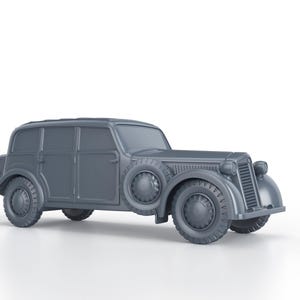 Peut inclure: Modèle de voiture vintage gris avec une carrosserie arrondie, quatre portes et une roue de secours à l'arrière. La voiture a une calandre et des phares chromés.