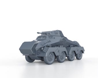 May include: A gray model of a German Sd.Kfz. 234/2 armored car. The model is detailed with a gun turret, wheels, and a front-mounted shield.