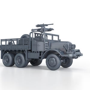 Op de afbeelding: Een grijs model van een militaire vrachtwagen met zes wielen, een laadbak en een gemonteerd machinegeweer. De vrachtwagen heeft een reservewiel en een gedetailleerde grille. Het model staat tegen een witte achtergrond.