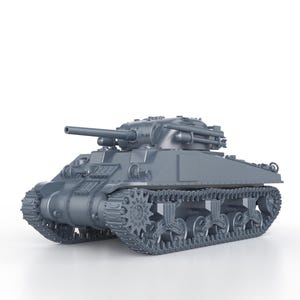 Peut inclure: Un modèle de char militaire en métal gris avec un gros canon sur le dessus. Le char a des chenilles et des roues et est sur un fond blanc.