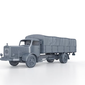 Op de afbeelding: Een grijs schaalmodel van een vintage vrachtwagen met een afgedekte laadbak. De vrachtwagen heeft een gedetailleerde grille met een cirkelvormig embleem, ronde koplampen en een cabine met een bestuurdersstoel. De wielen zijn zichtbaar, op een witte achtergrond.