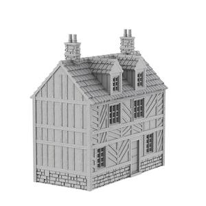 Op de afbeelding: Een grijs model van een huis met twee verdiepingen, een zadeldak, twee schoorstenen en een stenen fundering. Het huis heeft een vakwerkgevel met ramen en een deur.