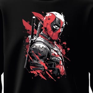Puede incluir: Sudadera negra con una ilustraci&oacute;n estilizada de Deadpool. El gr&aacute;fico muestra a Deadpool con su traje rojo y negro, con espadas y salpicaduras rojas. La obra de arte tiene un estilo de c&oacute;mic.