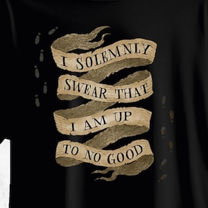 May include: A black t-shirt featuring a graphic of a tan, weathered parchment scroll divided into four horizontal sections. The text "I SOLEMNLY SWEAR THAT I AM UP TO NO GOOD" is printed in black serif font across the scroll, with small footprints.