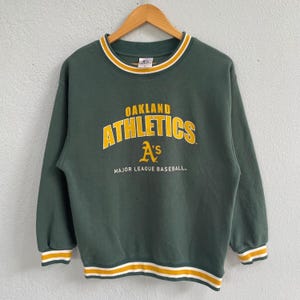 May include: Dark green Oakland Athletics sweatshirt with gold and white trim. The front features the team name "Athletics" in gold lettering, with the "A's" logo and "Major League Baseball" text below.