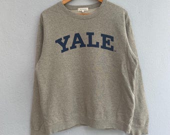 May include: A gray sweatshirt with a navy blue "YALE" logo printed on the front.