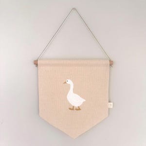 Banner de lona con ganso bordado: Decoración de pared neutra para habitación infantil.