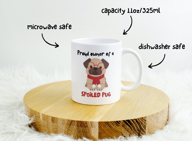 K&ouml;nnte beinhalten: Wei&szlig;e Keramiktasse mit einem Mops, der eine Brille und einen roten Schal tr&auml;gt. Auf der Tasse steht "Proud owner of a SPOILED PUG". Sie hat ein Fassungsverm&ouml;gen von 325 ml und ist mikrowellen- und sp&uuml;lmaschinenfest.