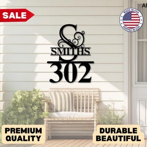 May include: Black metal house number sign with the family name "Smiths" and the number "302". The sign is mounted on a white wall above a wooden bench. The word "SALE" is in a red banner.