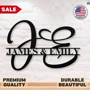 May include: Black metal wall decor with the letters "J & E" intertwined, with the names "JAMES & EMILY" written below in a banner style.