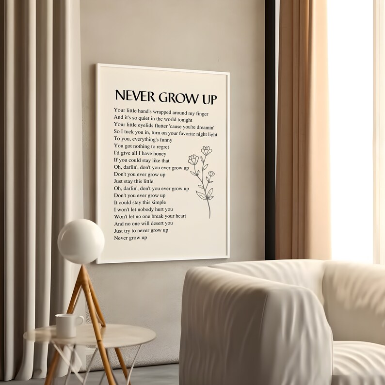 May include: A printable wall art poster with a white background and black text. The text reads "Never Grow Up" and includes a poem about staying young at heart. The poster features a simple line drawing of a flower.