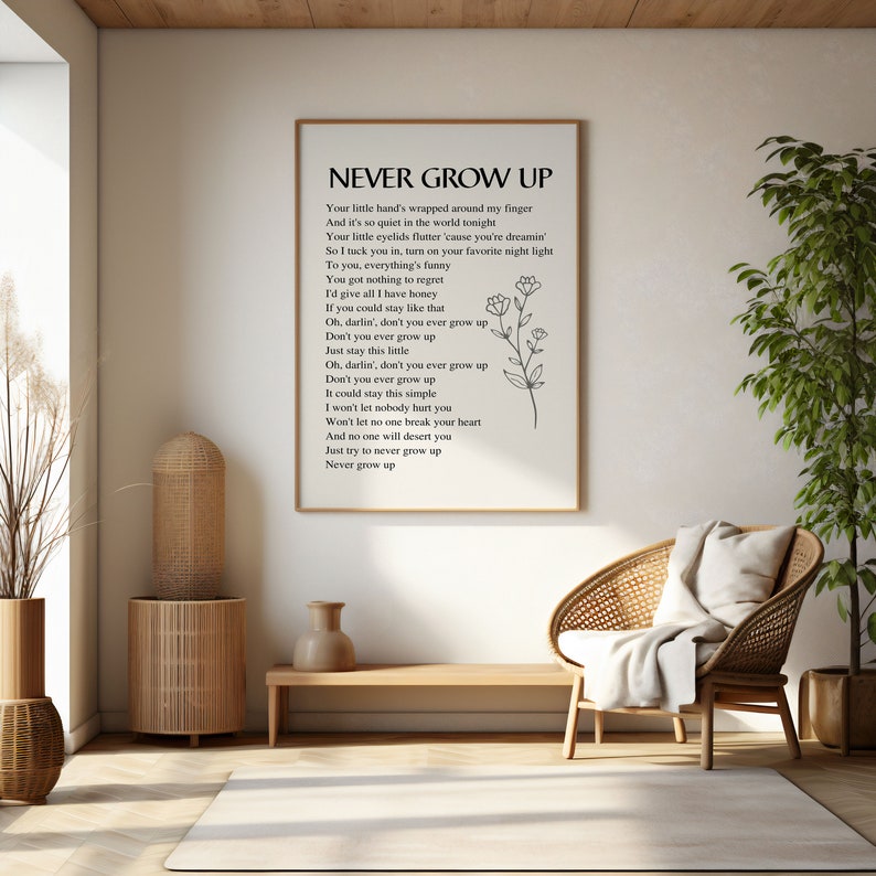 May include: A black and white printable wall art print with the lyrics to the song "Never Grow Up". The lyrics are printed in a simple font and are centered on the page. A simple floral design is in the bottom right corner of the print.