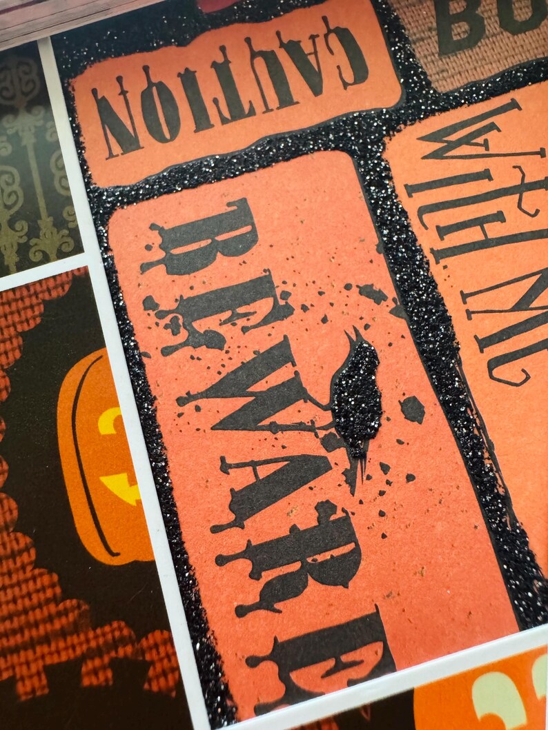 K&ouml;nnte beinhalten: Eine dekorative Collage mit rechteckigen orangefarbenen Feldern, schwarzem Text mit der Aufschrift CAUTION und BEWARE sowie einem schwarzen Glitzerrand. Das Design umfasst eine schwarze Glitzer-Kr&auml;hensilhouette und ein K&uuml;rbis-Motiv.