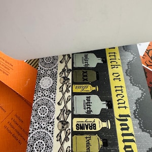 K&ouml;nnte beinhalten: Ein dekoratives Papierblatt mit einem vertikalen Muster aus Totenk&ouml;pfen und Knochen, einer Reihe beschrifteter Zaubertrankflaschen und einem gelben Streifen mit dem Text trick or treat halloween. Das Design enth&auml;lt ein schwarz-wei&szlig;es Spitzenmuster.