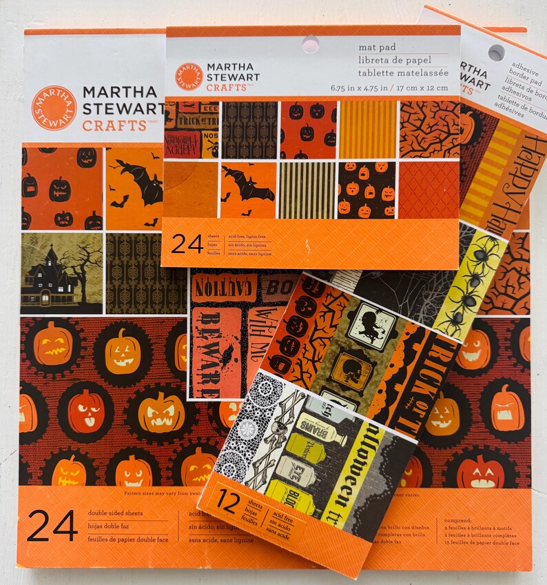 K&ouml;nnte beinhalten: Eine Sammlung von Martha Stewart Crafts Halloween-Papierbl&ouml;cken und Bord&uuml;ren mit orangefarbenen, schwarzen und braunen Mustern aus K&uuml;rbissen, Flederm&auml;usen, Spukh&auml;usern und Texten wie 'Trick or Treat' auf 24 doppelseitigen Bl&auml;ttern.