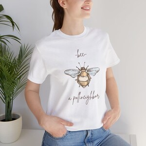 May include: White t-shirt with a bee illustration and the text "bee- a pollin'neighbor"