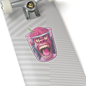 May include: A pink plastic cup with a brain inside and a monkey face on the front. The monkey is screaming with its mouth open and tongue sticking out. The cup has a straw sticking out of it.