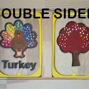 May include: Two wooden panels with yellow frames. One features a turkey illustration with the word "Turkey" below. The other panel shows a tree illustration. The text "DOUBLE SIDED" is at the top.