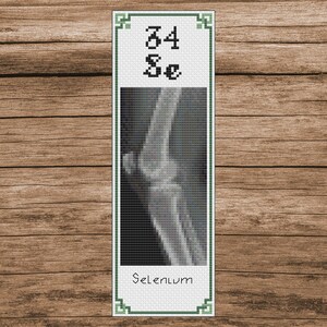 May include: Cross-stitch bookmark with a green border and a black and white image of a human knee x-ray. The bookmark also includes the text "34 Se" and "Selenium".