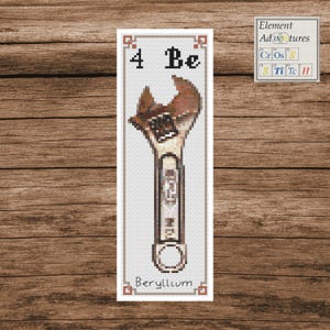 May include: A cross-stitch design of a wrench, labeled "Beryllium" with the symbol "Be" and atomic number "4". The wrench is brown and beige, set against a white background with a decorative border. The text "Element Adventures" is also visible.