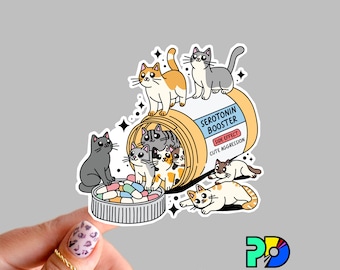May include: A cartoon illustration of a pill bottle labelled "Serotonin Booster" with a side effect of "Cute Aggression". The bottle is overflowing with adorable cartoon cats.