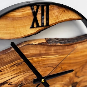 Detail shot of olive wood wall clock hands and metal frame craftsmanship.