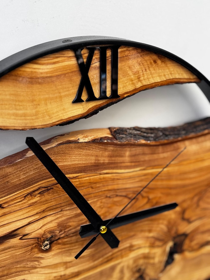Detail shot of olive wood wall clock hands and metal frame craftsmanship.