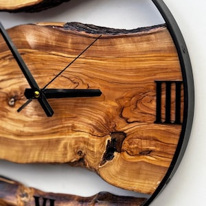 Unique handmade olive wood clock highlighting deep grain and warm tones.