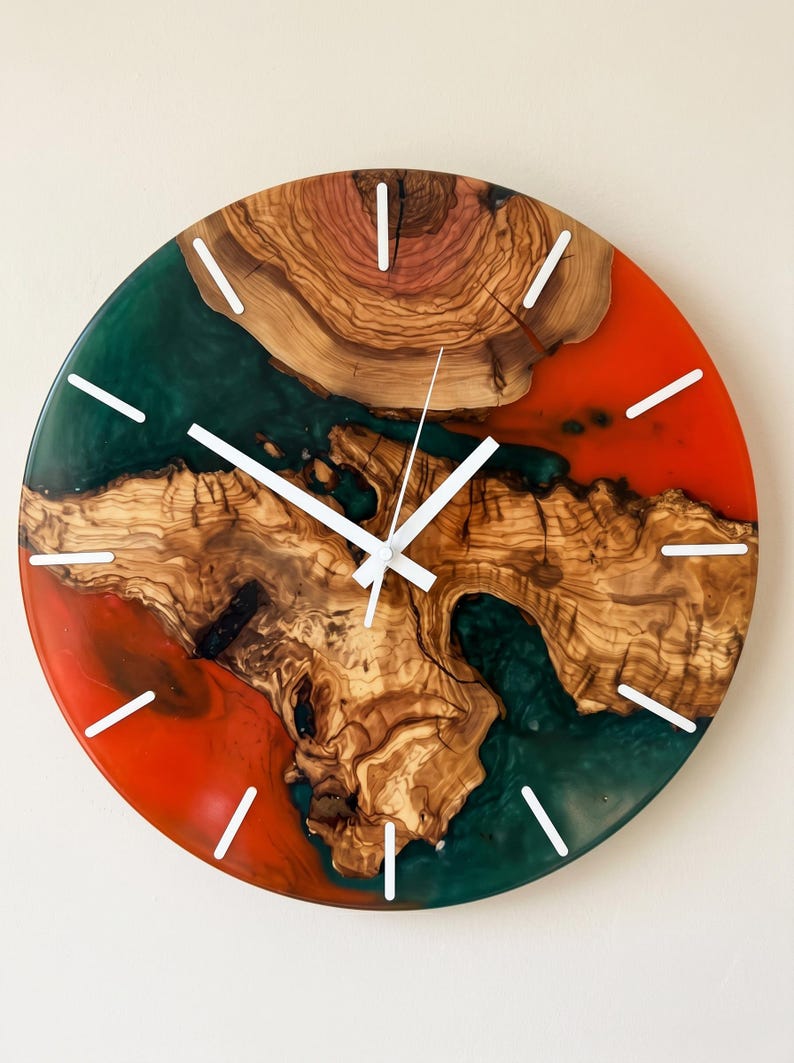 Handmade olive wood and epoxy resin wall clock featuring white. Natural live edge wood grain, and artisan craftsmanship, designed as luxury rustic wall decor for modern and farmhouse interiors.