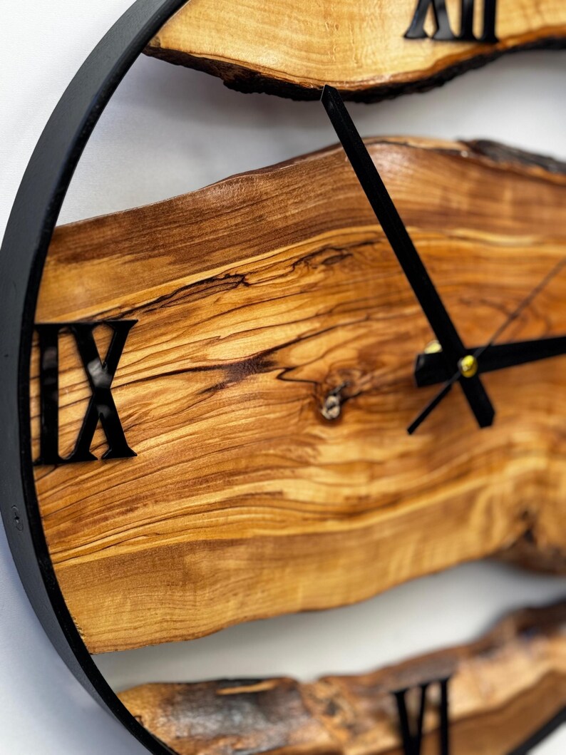 Natural live edge olive wood clock displayed against a clean white wall.