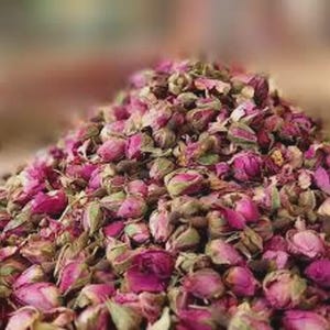 Könnte beinhalten: Ein großer, kegelförmiger Haufen getrockneter Rosenknospen. Die Knospen bestehen aus einer lebendigen Mischung aus tief magentafarbenen und zartrosa Blütenblättern, durchsetzt mit getrockneten grünen Kelchblättern und Stielen. Die Textur wirkt trocken.