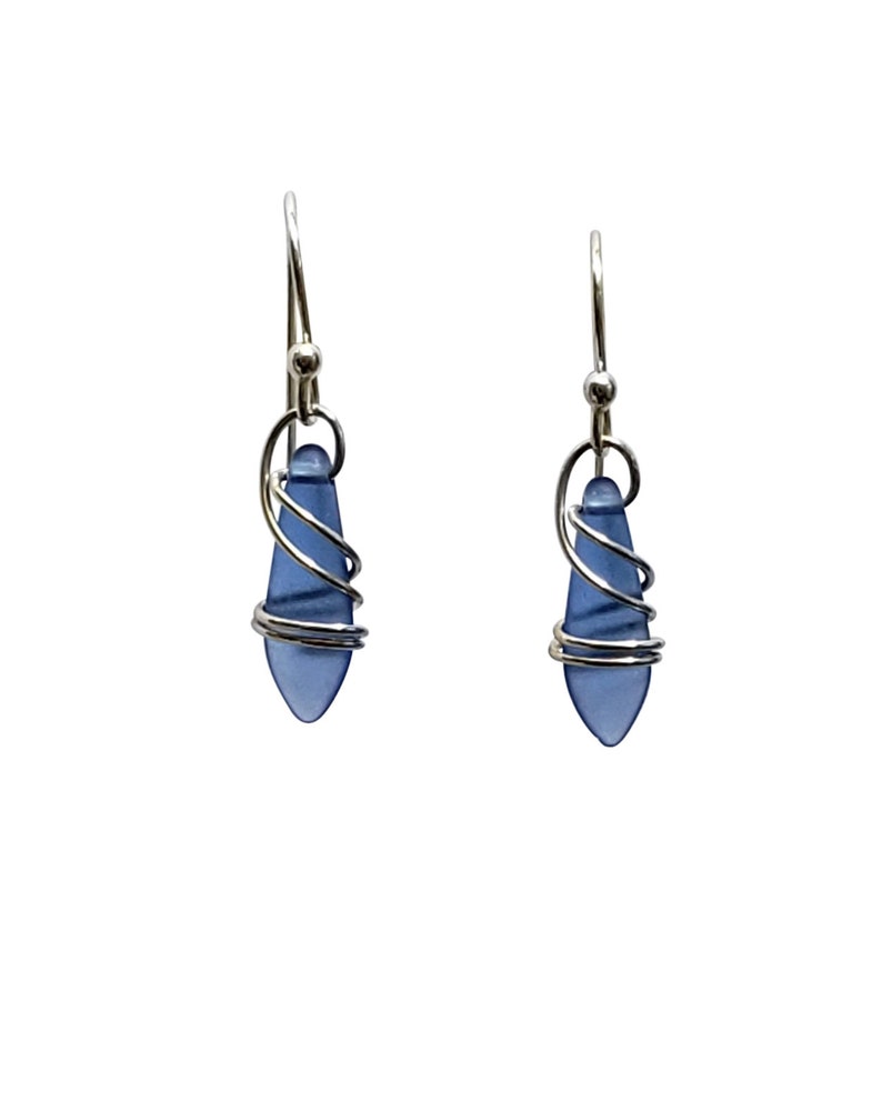 Ear wires are sterling silver, handmade with deep blue satin finish dagger glass beads. Length is 3/4 inches. Delightedly hand wrapped in sterling silver. Gift box included. Looks like blue sea glass.