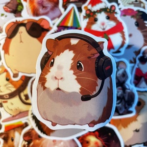 May include: A sticker of a brown and white guinea pig wearing a headset. The guinea pig has a brown head and brown ears, and a white face and body. The headset is black with a microphone.