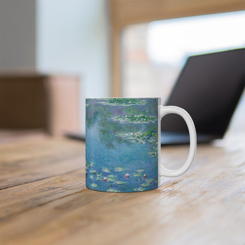 Puede incluir: Taza de cer&aacute;mica blanca con una imagen azul y verde de nen&uacute;fares y un cielo azul. La imagen es una reproducci&oacute;n de una pintura famosa.