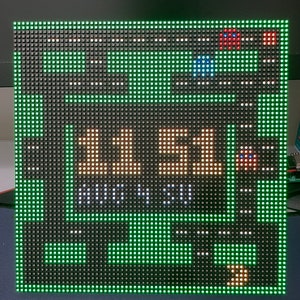 May include: A green LED display with white text showing "11.51" and "NOON". There are red and blue lights on the top of the display.