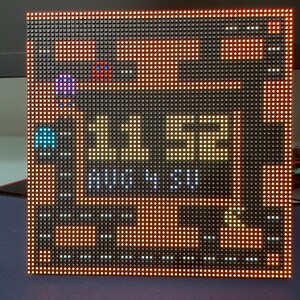 May include: A pixelated LED display showing a video game with a score of 1152 and the text "HIGH SCORE". The game features a red and blue character and a yellow character.