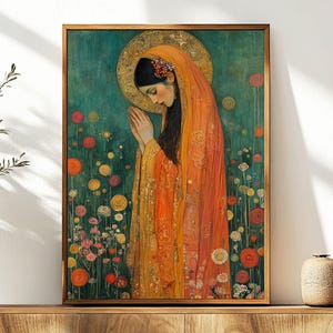 May include: A painting of a woman in a flowing orange robe with a halo, praying with her hands clasped together. The background is a teal green with small flowers.