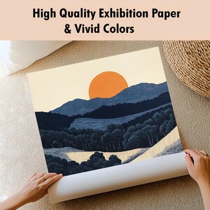 May include: A rolled print of a landscape painting featuring a large orange sun, blue mountains, and dark green trees. The text at the top reads "High Quality Exhibition Paper & Vivid Colors."