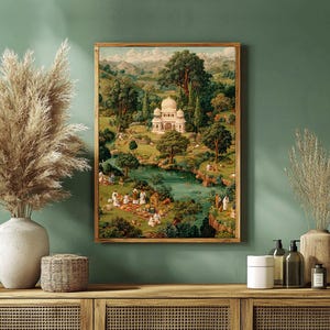 May include: A framed print of a landscape scene featuring a white domed building surrounded by lush greenery, a river, and figures. The artwork has a vintage aesthetic with warm tones and a wooden frame, creating a serene and picturesque view.