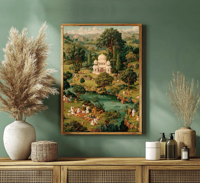 May include: A framed print of a landscape scene featuring a white domed building surrounded by lush greenery, a river, and figures. The artwork has a vintage aesthetic with warm tones and a wooden frame, creating a serene and picturesque view.