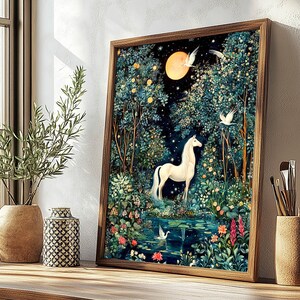 May include: A framed vertical wall art print featuring a white unicorn standing in a lush, dark forest at night. A large, glowing yellow moon hangs in the sky above the unicorn, surrounded by dense trees, colorful flowers, and white birds.