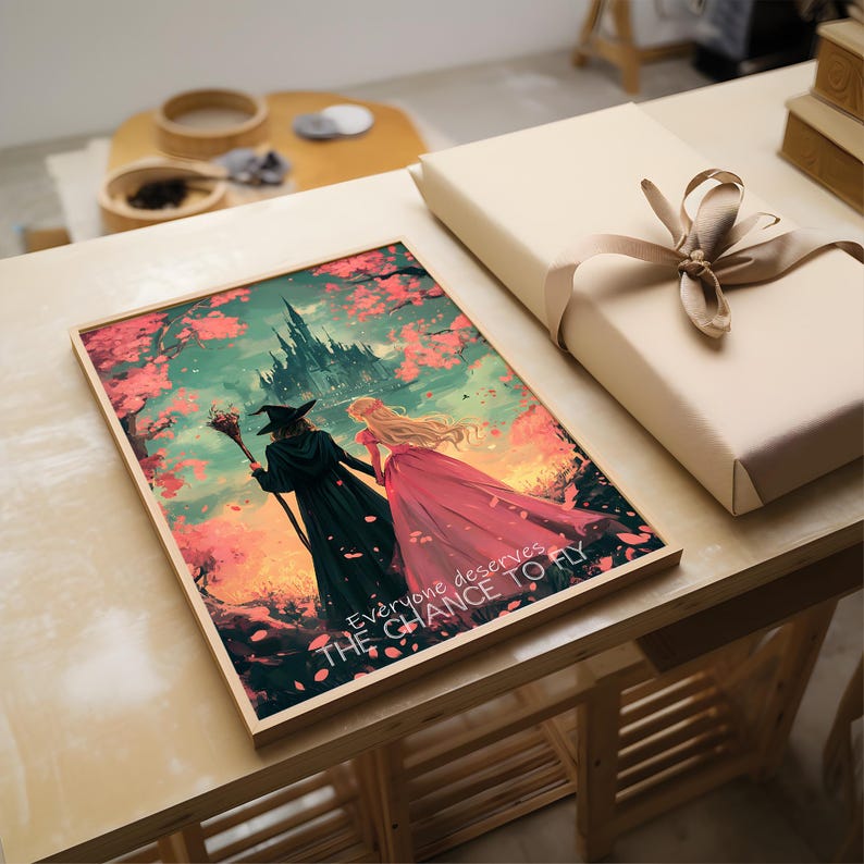 May include: A framed print with a fantasy illustration of two women walking away from a castle. The woman on the left is wearing a witch's hat and robe, and the woman on the right is wearing a pink dress. The background is a colorful sunset with pink cherry blossoms falling from the trees. The text "Everyone deserves the chance to fly" is printed at the bottom of the print.