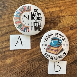 May include: Two white round buttons with text and graphics. One button says "SO MANY BOOKS - SO LITTLE TIME" with a clock design. The other says "HAPPY PEOPLE DRINK COFFEE AND READ BOOKS" with a coffee cup on books.
