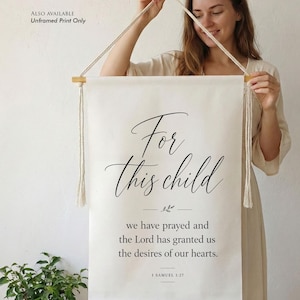 Könnte beinhalten: Handgefertigter Wandbehang aus Baumwolle mit dem Schriftzug "For this child". Der cremefarbene Banner aus 100 % reiner Baumwolle enthält den Bibelvers 1 Samuel 1:27. Aufhängfertig, erhältlich in verschiedenen Größen von 20x30 cm bis 61x91 cm.