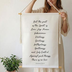 Könnte beinhalten: Ein handgefertigter Wandbehang aus Baumwolle mit dem Text: But the fruit of the Spirit is Love, Joy, Peace, forbearance, Kindness, Goodness, faithfulness, Gentleness and Self-Control. Against such things there is no law. GALATIANS 5:22-23.